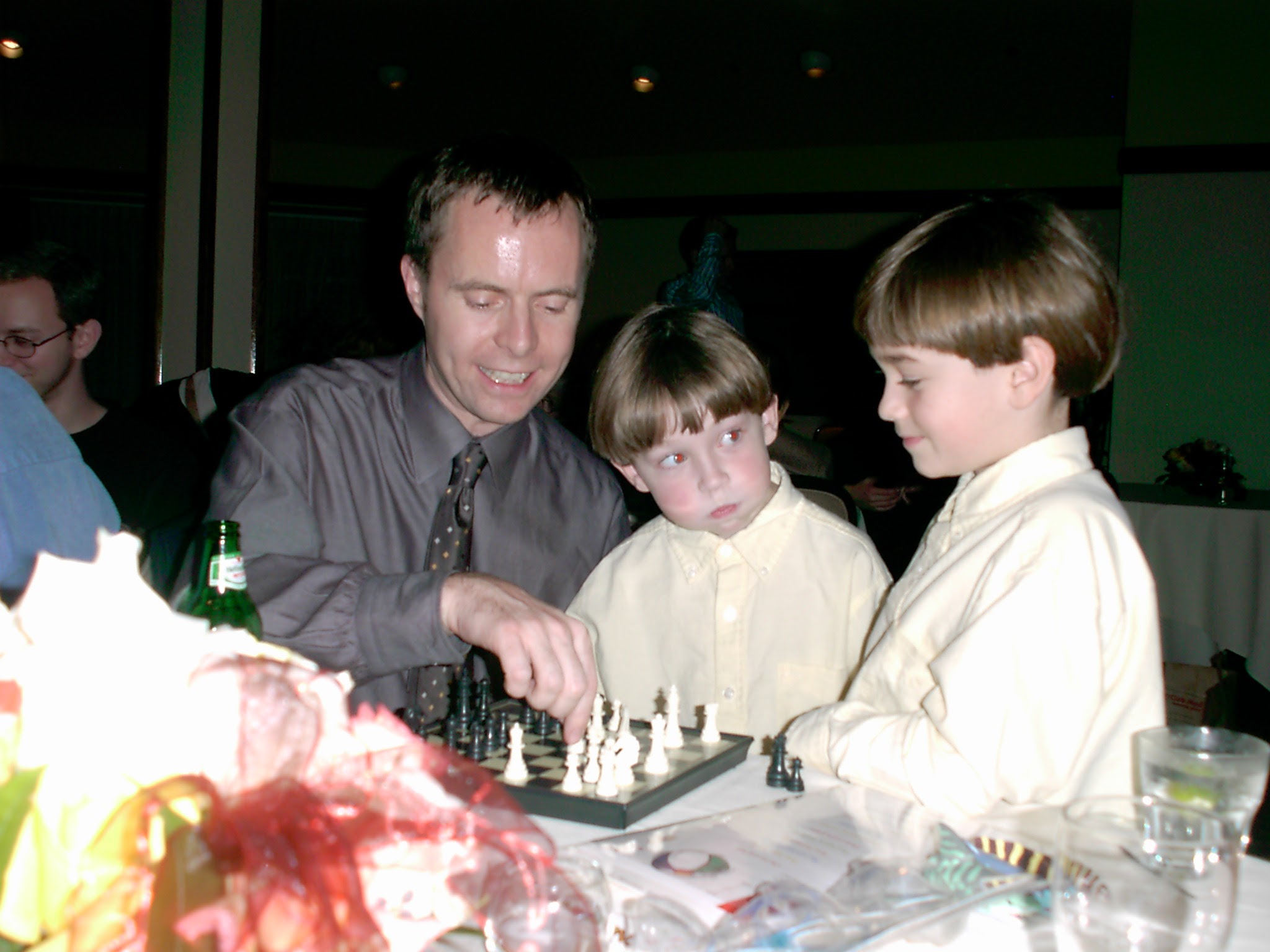 Chris and his brother playing chess against a drunk man